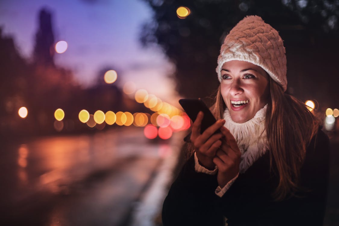 Woman recording a voice message on her smartphone in the street